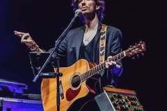 Luca Zabbini singing with acoustic guitar on the PFM tour
