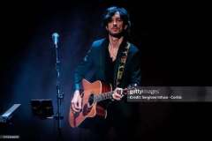 Luca Zabbini with acoustic guitar on stage with PFM