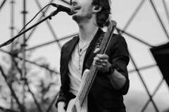 Luca Zabbini playing guitar on stage with PFM, black and white