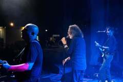 PFM live on stage under blue lights
